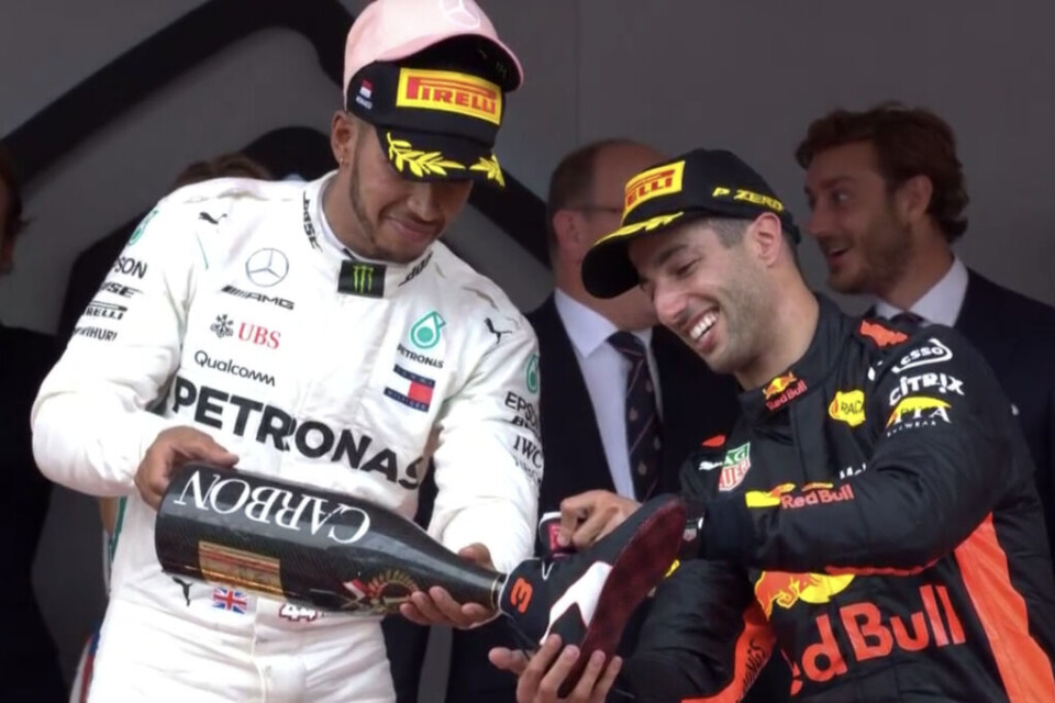 Lewis Hamilton hjelper Daniel Ricciardo med å forberede en klassisk «shoey» som er blitt Red Bull-førerens store varemerke. (Skjermdump: Viasat 4)