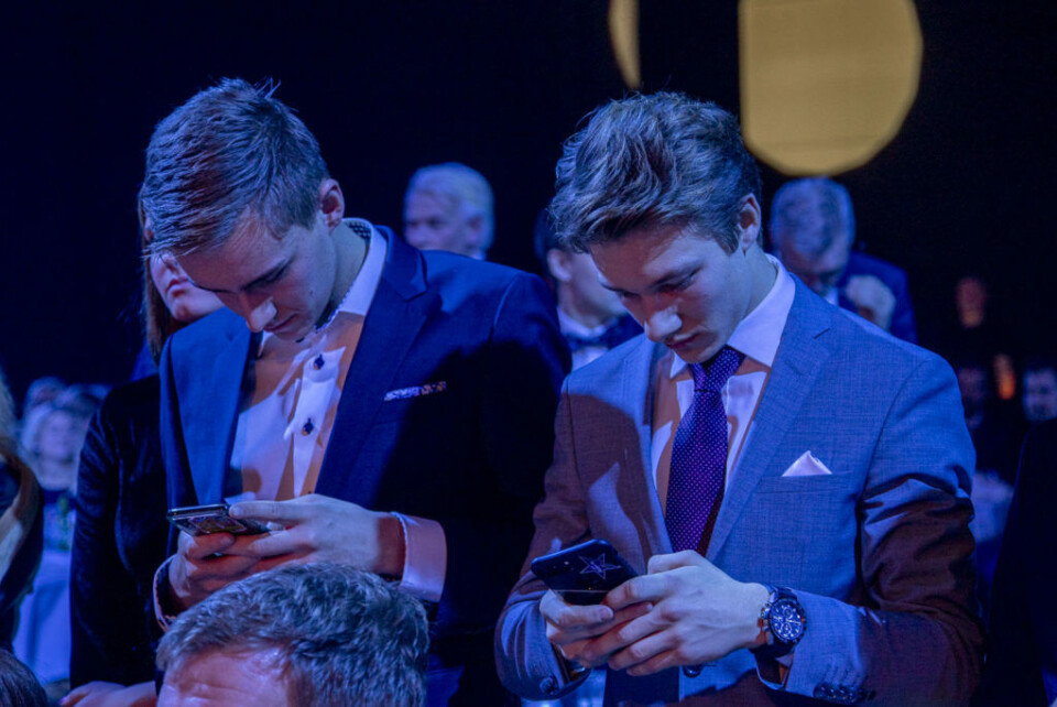 Mobilen er sjeldent mer enn en liten håndsrekning unna for Dennis Hauger og de fleste andre i hans generasjon. Her fra Bilsportgallaen i 2018 sammen med en annen bilsportutøver, Marcus Påverud. (Foto: Simen Næss Hagen / Parc Fermé)