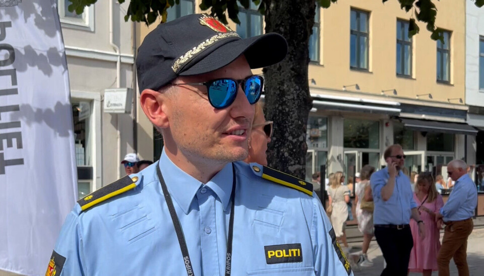 Politimann foran et tre i en folkemengde under Arendalsuka 2022.